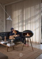 Oscar black tripod bioethanol fireplace lit in a family living room, ARDĒO